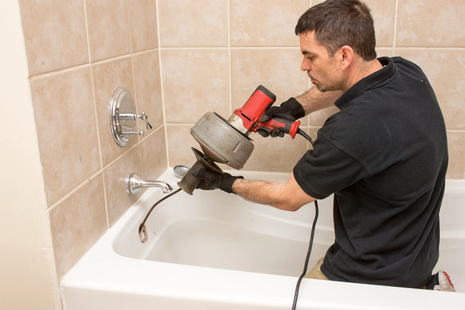 Technician cleaning a drain pipe in Doha