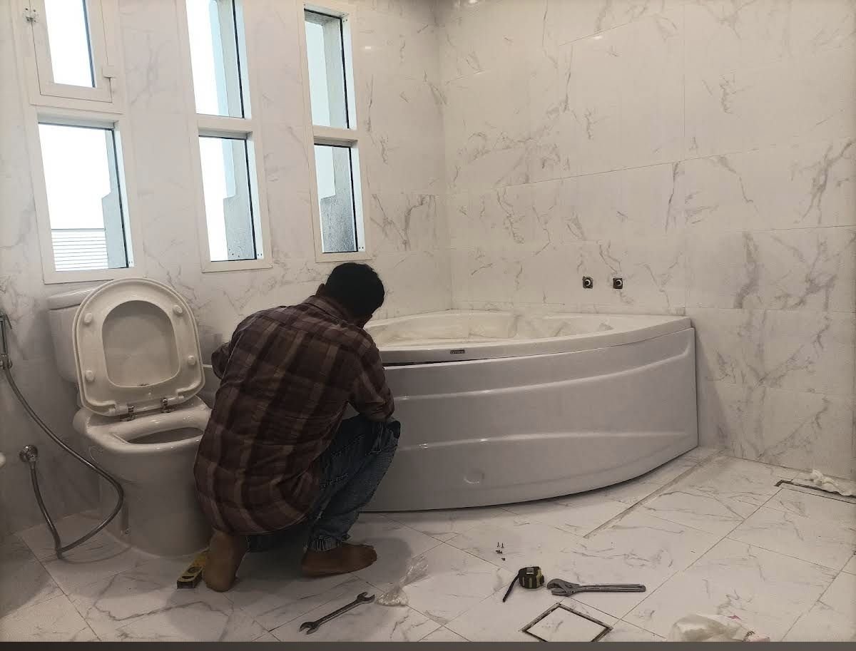 Technician working on bathtub plumbing