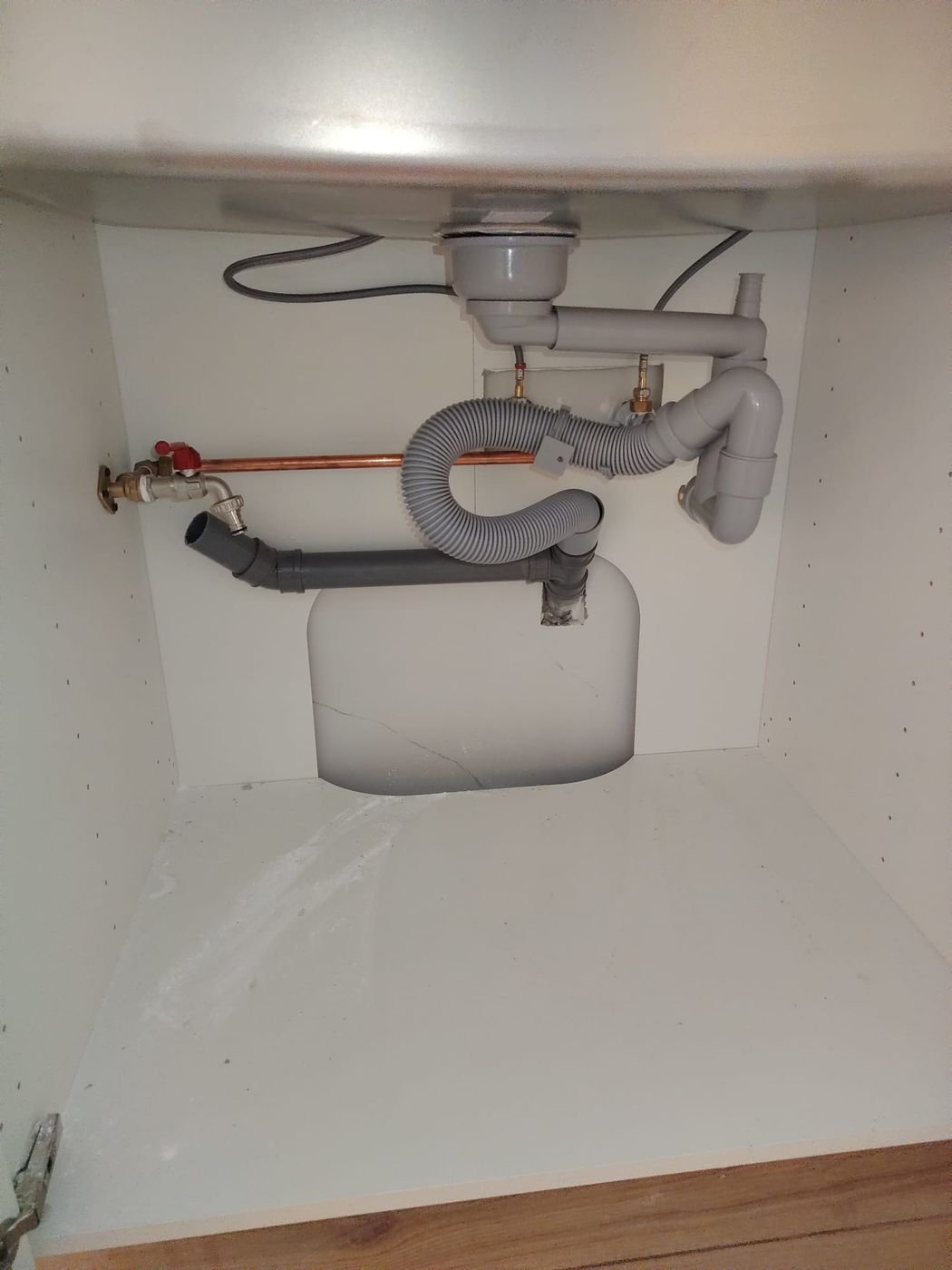 New PVC drain pipes inside a kitchen cabinet