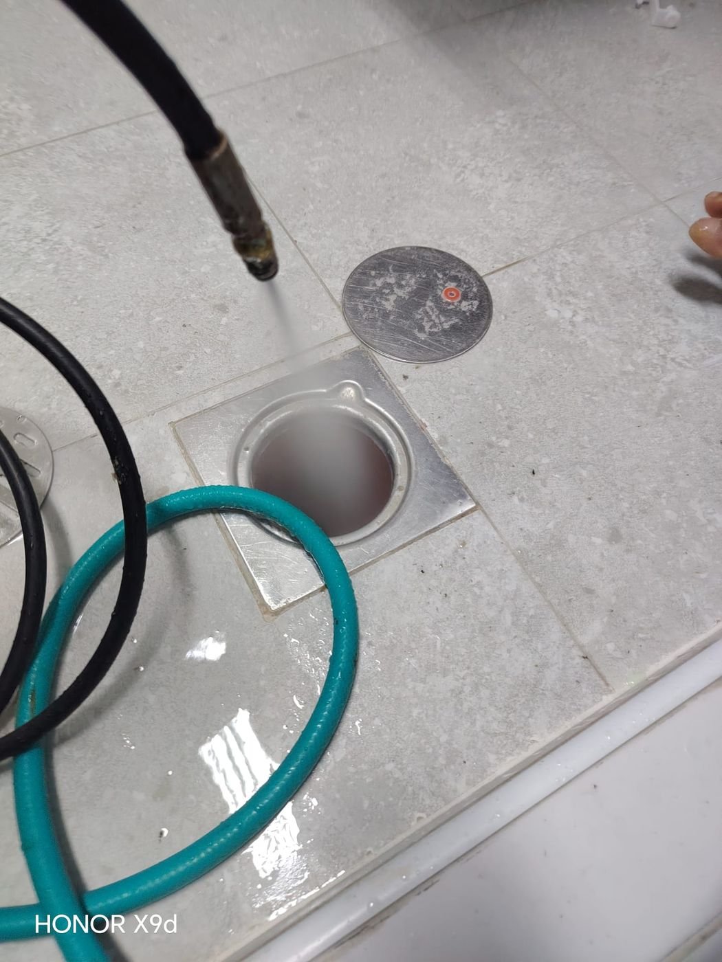 Floor drain being flushed and cleaned