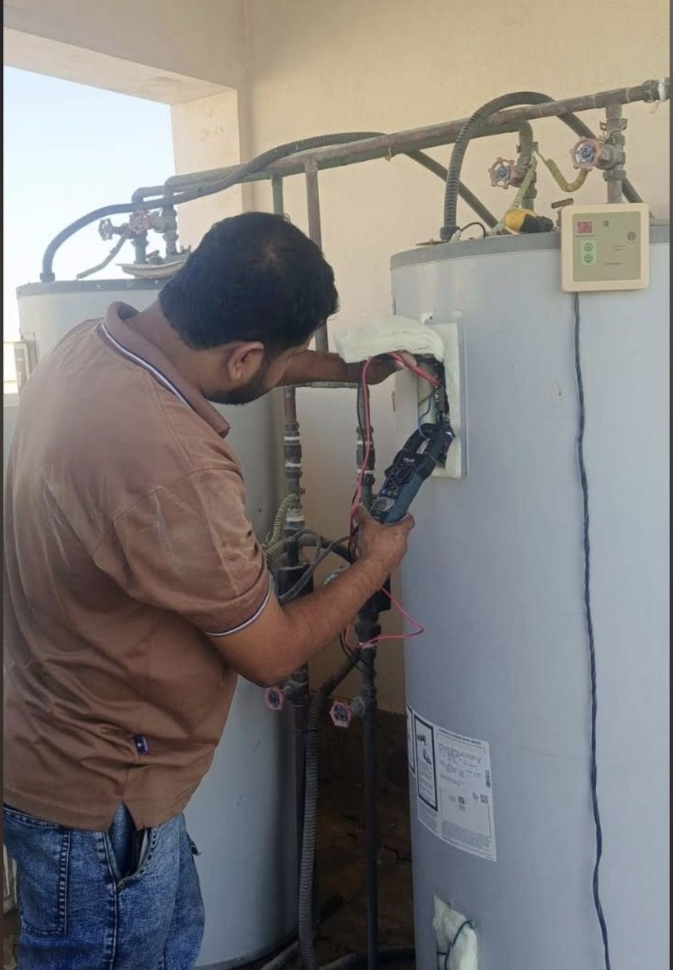 Technician repairing the pipes of a large water heater