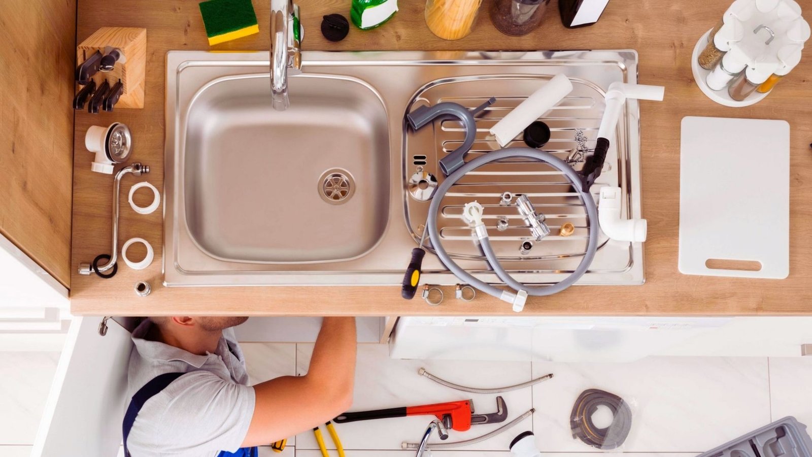 Technician servicing an indoor Kitchen plumbing
