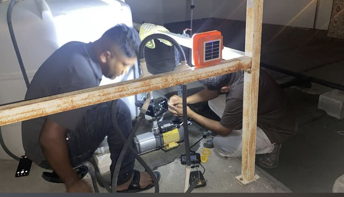 Two technicians repairing a water pump at night