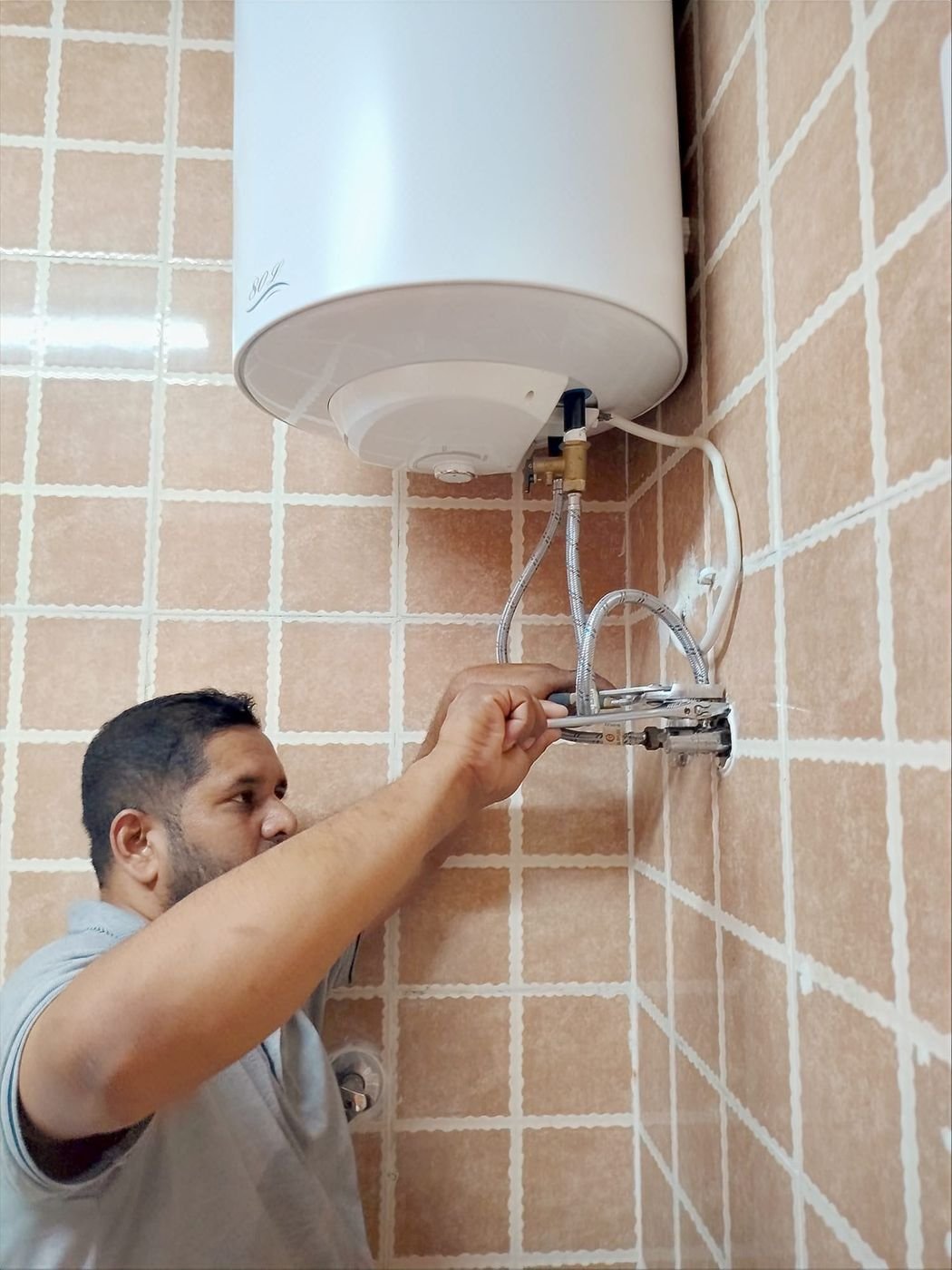 Technician installing a water heater in a Doha home
